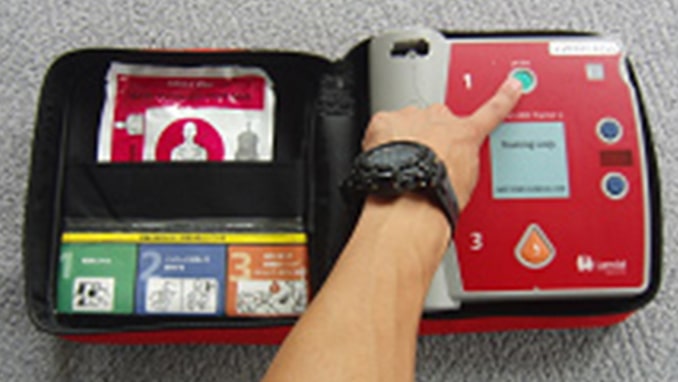 AEDの電源を入れている写真